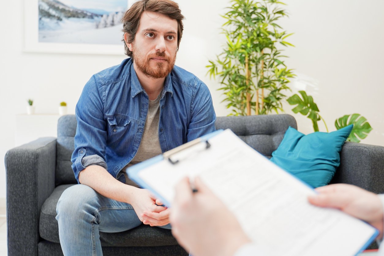 Doctor consulting male patient, working on diagnostic examination of mental illness